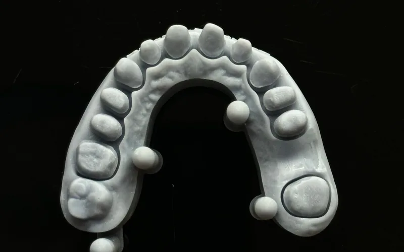 Modelo impreso de una arcada con todos los dientes tallados, con el margen de cada muñón marcado